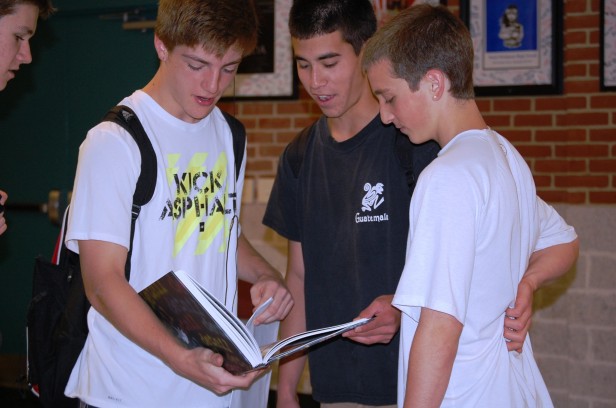 Some freshman boys flip through this years edition of SAGA, the yearbook. Today was the first day students from all grade levels could pick up their yearbooks. Photo by Melissa Kantor.