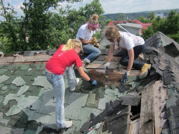 Sophomore Anna Volkov (left) and juniors Corinne Lake (center) and Melanie Goldberg remove shingles from a roof of a condemned house in Pulaski, Virginia. The Whitman Relief Network club traveled to the town JUne 19 to 24 to aid rebuilding efforts after a disastrous tornado. Photo couirtesy Melanie Goldberg.