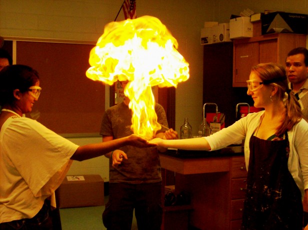 AP Chemistry students Shruti Gujaran (left) and Lydia Koroshetz light methane bubbles on fire in class June 2. The students are completing a bubble unit for their final project. Photo by Jenny Finley.