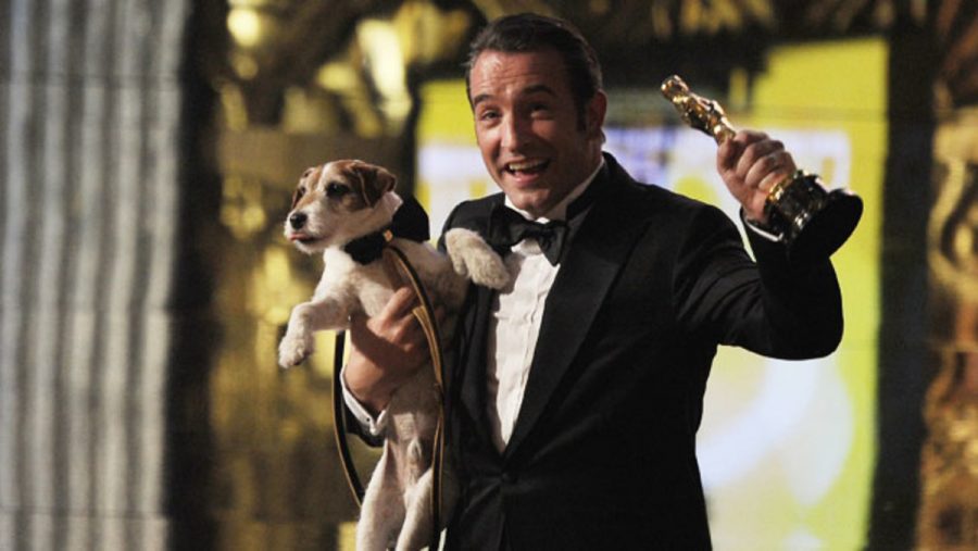 Jean Dujardin, who won Best Actor for The Artist, celebrates the films Best Picture win with the films other star, the dog Uggie, at the 84th Academy Awards. The Artist and Hugo led the night, with both five wins each. Photo courtesy www.hollywoodreporter.com.