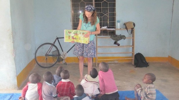 Senior Michelle Huey reads a picture book to the children of the Tanzania orphaniage. 13 students traveled to Tanzania this past summer with history teacher Michael Curran.