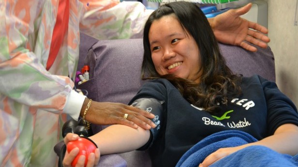 A student squeezes a stress ball as a nurse takes her blood. Twenty students donated blood to benefit Childrens Hospital today. Photo by Abigail Cutler.