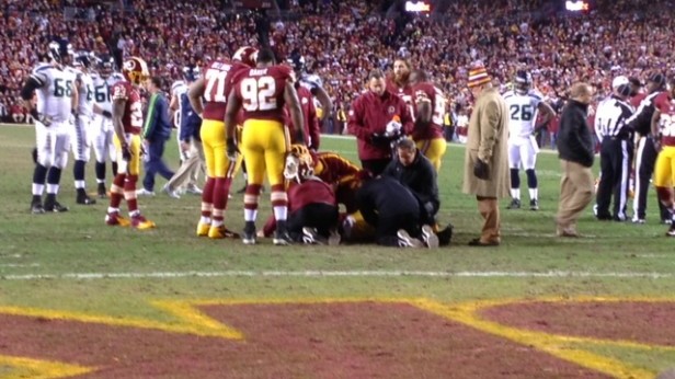 Redskins players and medical staff huddle around rookie phenom Robert Griffin III after he re-injured his knee in the fourth quarter. Photo by Nick Sobel.