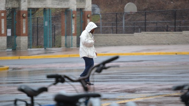 A teacher walks in the rain during the school day today. The torrential downpour let up around 1 p.m. Photo by Abigail Cutler.