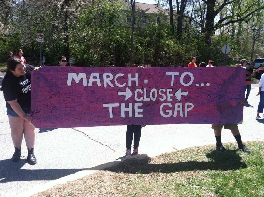 Students hold a sign supporting the March to Close the Gap. Photo by Sarina Hanfling.