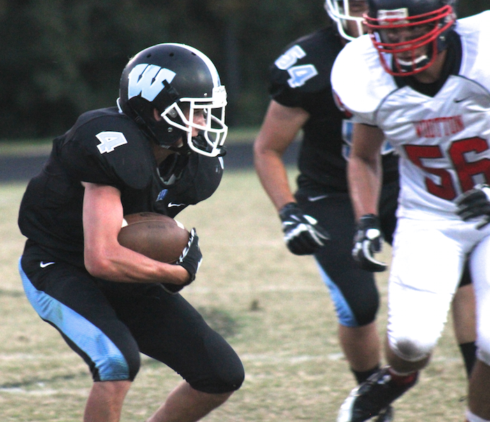 Running back Gunnar Morton braces for contact as he runs toward a Wootton defender. Photo by Nick Anderson.