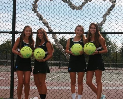Seniors Zoe Humeau, Ali Dane, Emilia Malachowski, and Maggie McGowan are presented with signed tennis balls by their teammates in honor of senior night. Photo courtesy Zoe Humeau.