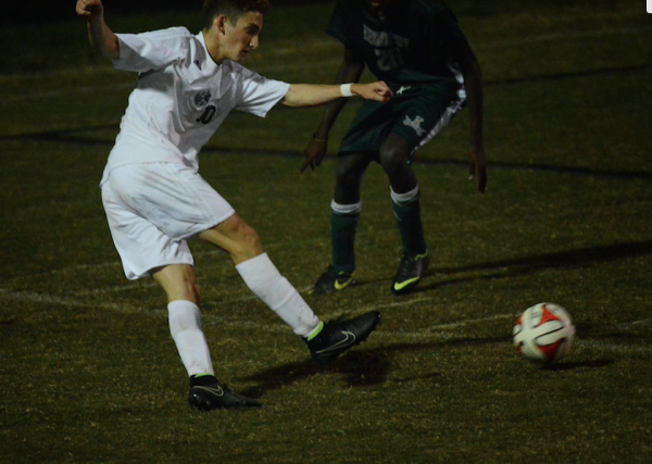 Forward Davey Mason works past a defender and takes a shot. Mason had three goals in Whitman's 4-1 playoff victory.  Photo courtesy Clive Harris. 