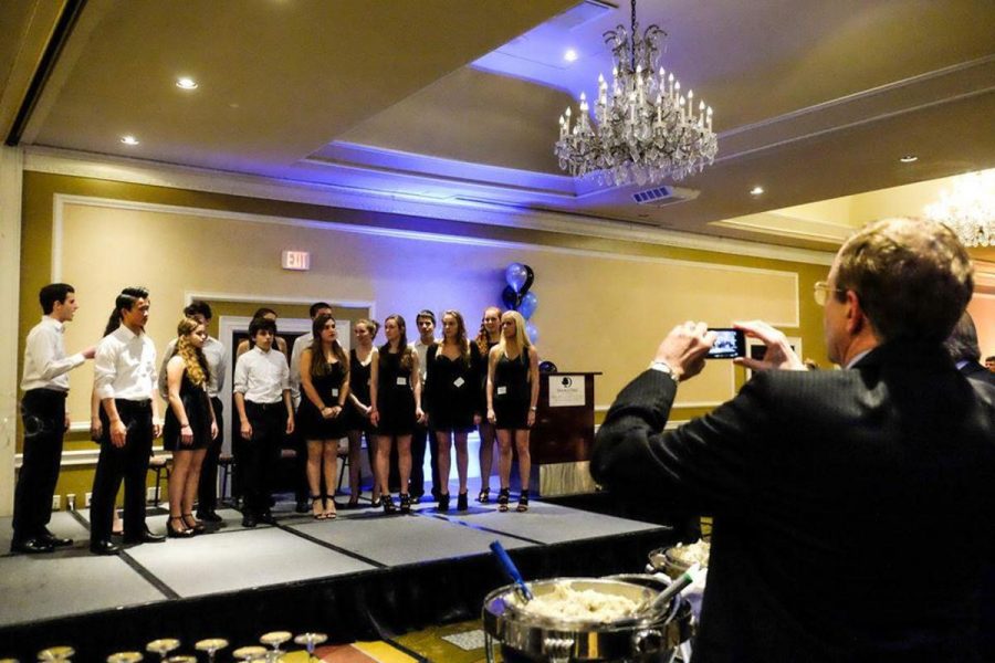 Principal Alan Goodwin takes a video of the student a capella group NOTA performance. Goodwin is known for both his involvement in student work and social media presence. Photo by Tyler Jacobson.