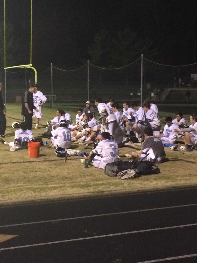 Coach Tommy Rothert refocuses and energizes the Boys Lacrosse team at halftime. Photo by Luke Graves
