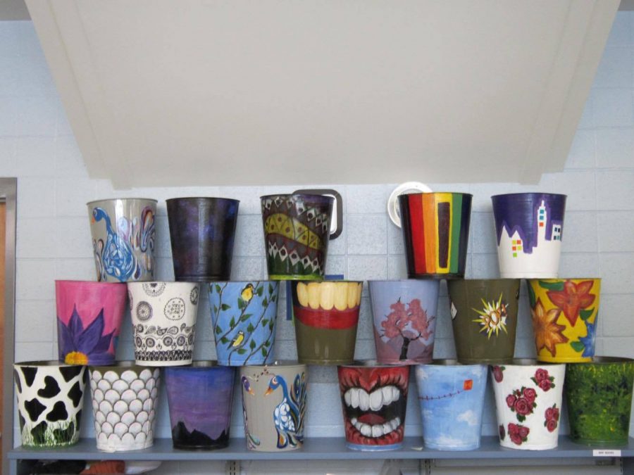 Art students designed trash cans to put on display in the media center. Art teacher Jean Diamond hopes that every classroom will have a one of these colorful trash cans in their classroom eventually. Photo by Allie Lerner.