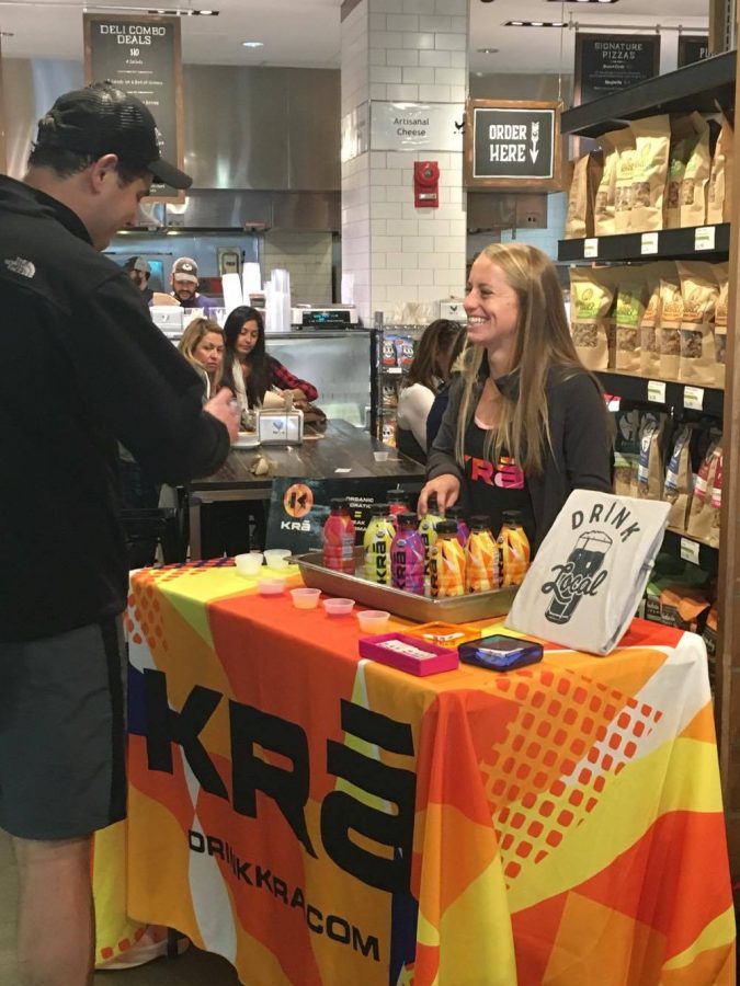 Shoppers try samples of  KRĀ, a new sports drink created by a Whitman parent, at Whole Foods. Photo by Abbi Audas. 