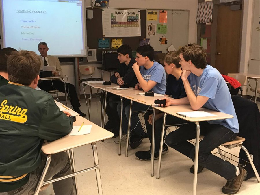 Senior Michael Hepburn, senior Ellis London, junior Braden Longstreth, and freshman Nate Olson practice buzzing in to answer questions as they prepare for their finals match Feb. 23 at Blair High School. Photo by Julie Rosenstein.