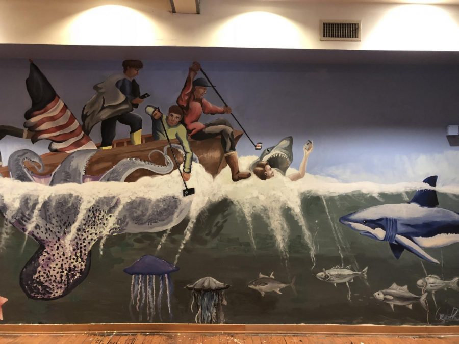 Fish and sharks swarm a wooden raft as an octopus grabs hold of a vessel in a mural in the Museum of Contemporary American Teenagers. B-CC students created the museum after an assignment in their IB Anthropology class. Photo by Rebecca Hirsh.