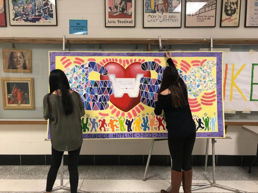 Students sign a banner in the front hall. Whitman students created the banner to honor the late Quince Orchard student Tyler Terry. Photo by Sydney Miller.