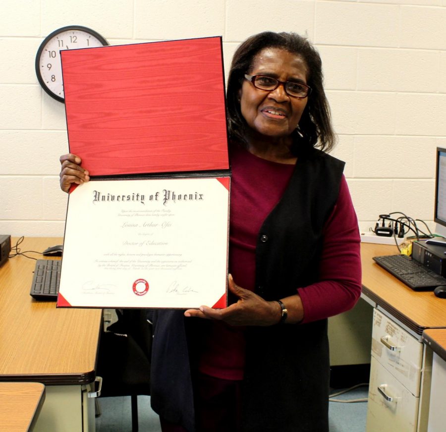 Paraeducator Louisa Arthur holds up her Ph.D. certificate from the University of Pheonix. Arthur earned her doctorate in education after seven years of online classes. Photo by Annabel Redisch.
