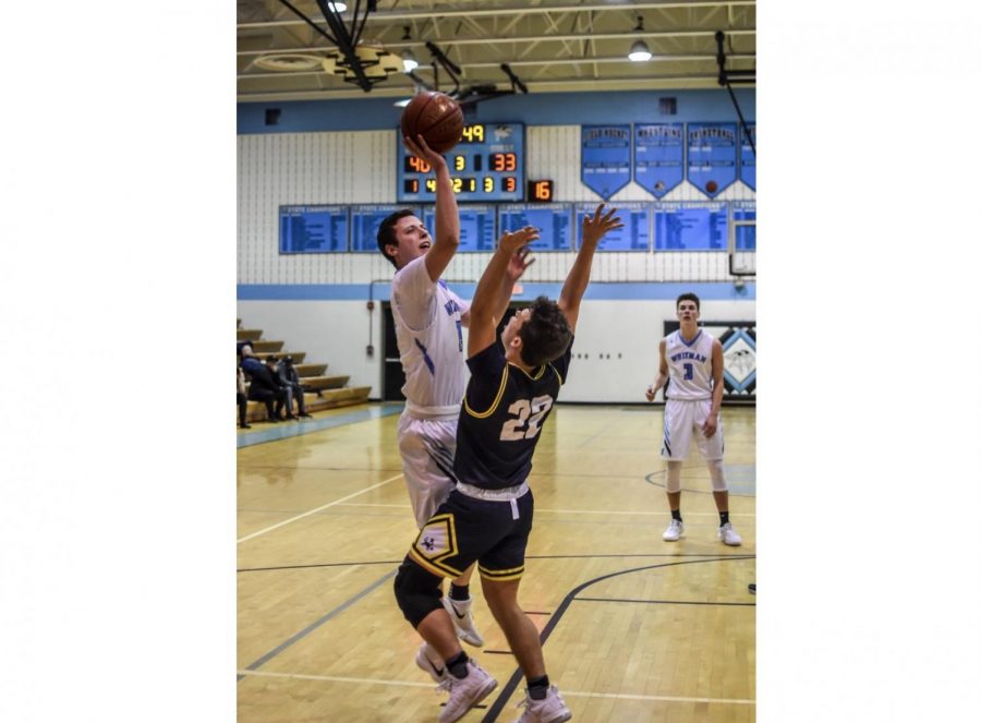 Forward Jason Lewis goes up for a contested layup in the teams 62–61 loss against rival B–CC. Photo by Ryan Gaines.