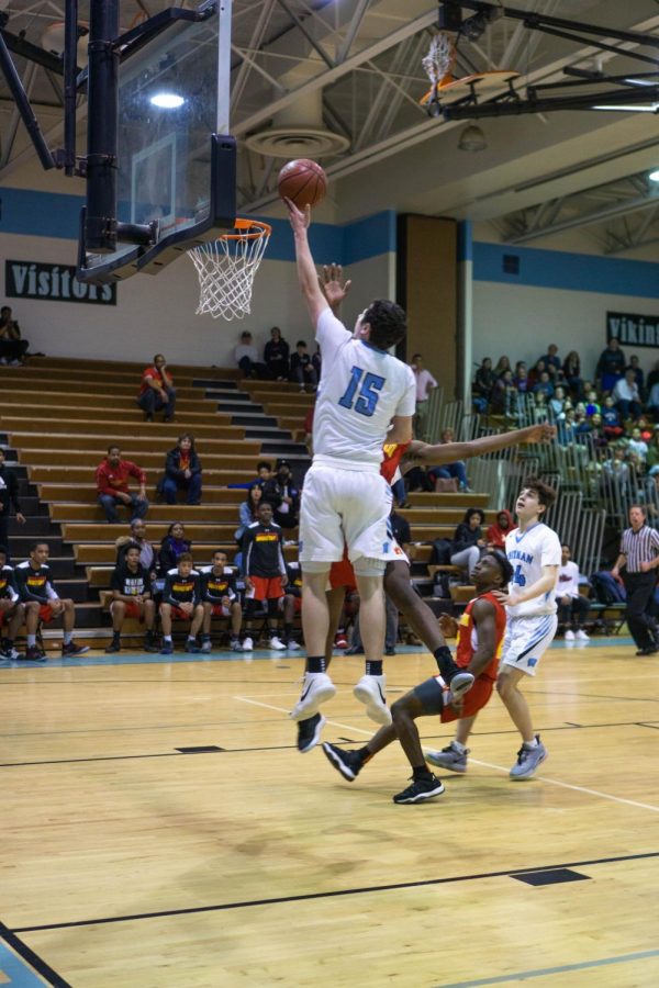 Forward Jason Lewis goes up for a contested layup in the boys basketball team's first round playoff win against the Wheaton Knights. Lewis has led the team in scoring this season.