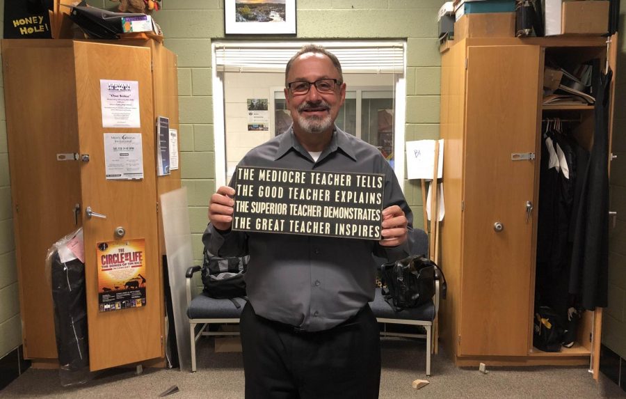 Chorus teacher Jeff Davidson holds up a sign he considers his inspiration for teaching. Davidsons relationship with his students is like that of an uncle, a mom, or dad, he said.