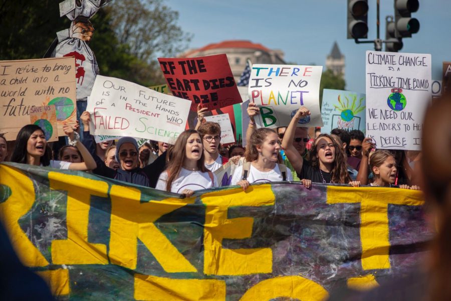 Students hold up a banner while chanting. The strike was filled with colorful signs with catchy but solemn slogans, mostly being held up by high school students.