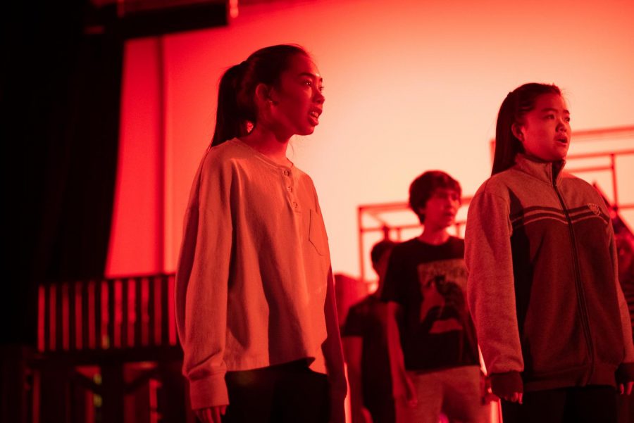 Actor Rachel Chen (left) sings with the ensemble during tech week.
