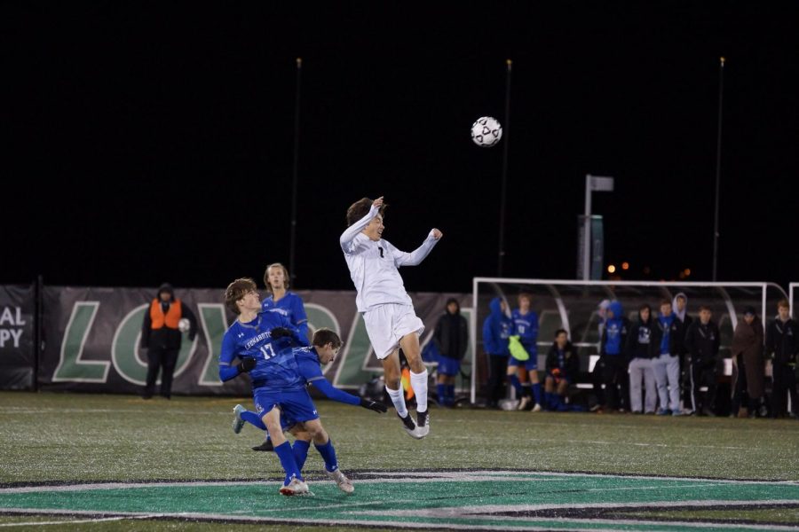 Gunther jumps to head the ball over three Leonardtown players.  