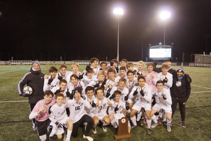 The Vikes pose with the championship trophy, holding up two fingers representing the eleventh state title for the boys soccer team. 