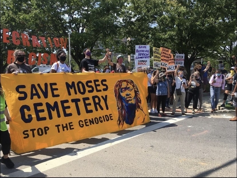 Members of the Anti-Racist Bethesda Coalition and the Bethesda African Cemetery Coalition stand in protest of Moses African Cemeterys demolition. Protests occur on the side of River Road.