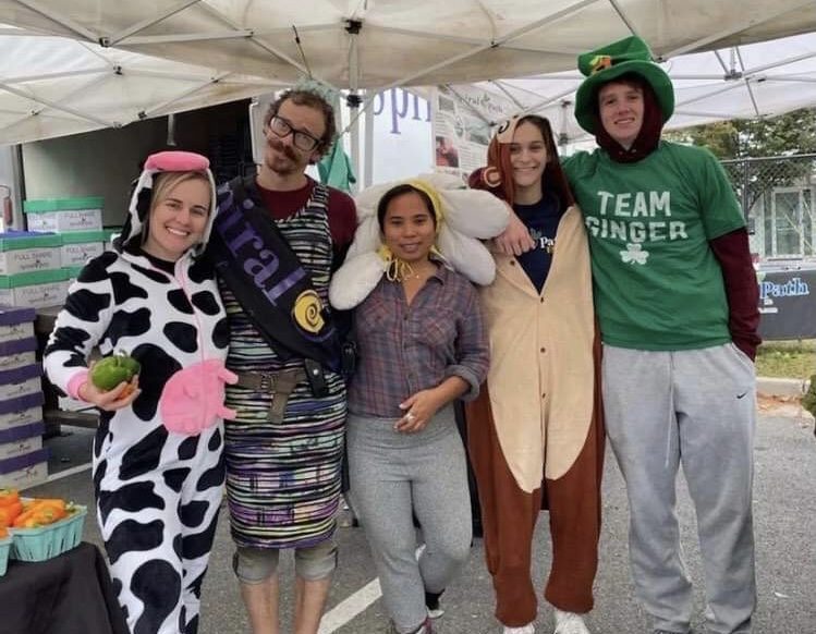 Senior Alex Aronie (second to right) posing with fellow employees at the Spiral Path Farm stand at Bethesda Farmers Market. 
