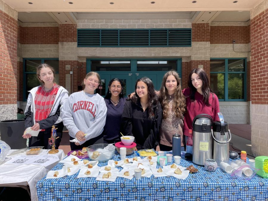 MSA members — (from left to right) Elif Ozel, Iman Hasnani, Renia Ahmed, Cate Cirivello, Naz Bolukbasi — pass out Islamic treats in the bus loop during lunch.